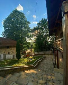 Gornja ToplicaKonaci Nikola Banja Vrujci的石头人行道,在一座树木繁茂的建筑前
