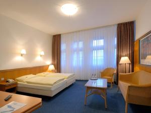 柏林AVUS汽车旅馆的大型酒店客房设有一张床铺和一张桌子。