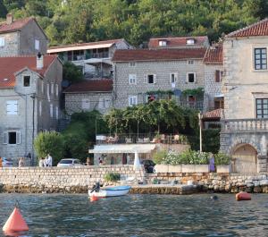 帕里斯特Guesthouse Žmukić的一群建筑物和一群水体,有船
