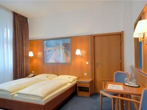 柏林AVUS汽车旅馆的酒店客房设有一张大床和一张书桌。
