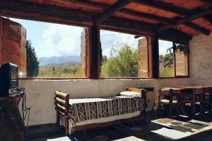波特雷罗德洛斯弗内斯Cabañas Los Arroyitos的客房设有大窗户、桌子和椅子。