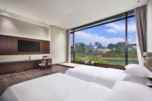 桂林中心璞云酒店(桂林两江四湖象鼻山公园店)的酒店客房设有两张床和大窗户。