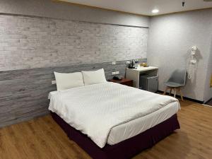 台南铁道大饭店的卧室配有一张白色大床和一张书桌