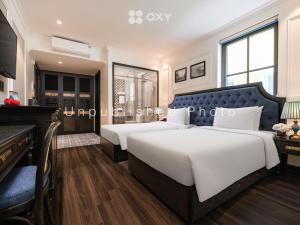 下龙湾Ha Long Essence Classic Hotel的一间卧室设有两张床和一个壁炉