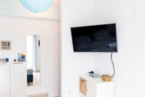 卡尔扎迈纳Sunrise的一间客厅,在白色的墙上配有电视