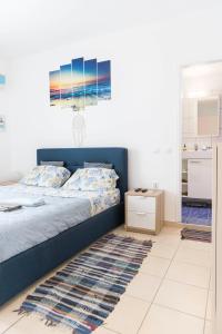 卡尔扎迈纳Sunrise的一间卧室配有蓝色的床和地毯