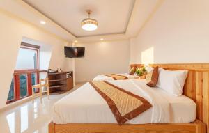 大叻Hoàng Yến Villa Dalat的一间卧室配有两张床和一台平面电视