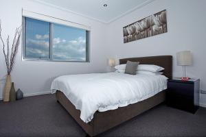 堪培拉Glebe Park Canberra City ACT的白色的卧室设有一张大床和一个窗户