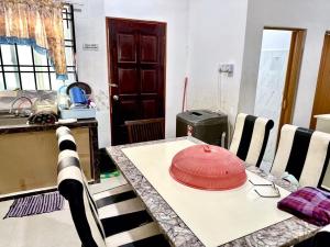 哥打丁宜Isyfaq Homestay 2 bedroom & 2 bathroom的坐在厨房桌子上的红帽