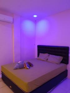 EkasSatu Hati Homestay的一间设有紫色灯床的房间
