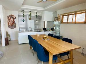 北谷町ResortHouse-KAPUKA的厨房以及带木桌和蓝色椅子的用餐室。
