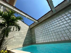 北谷町ResortHouse-KAPUKA的一座带游泳池和砖墙的房子