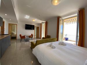芒通Villa l'ensoleillée vue panoramique mer, 250 m de la plage et du centre ville的酒店客房设有一张大床和一间客厅。