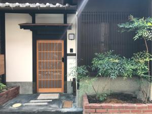 京都Third&Place Kyoto_ShijoOmiya/四条大宮的一座带木门和一些植物的房子