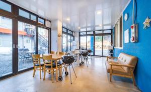 襄阳郡Sky Sea Pension的一间配备有桌椅和蓝色墙壁的餐厅