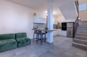 马尔萨拉Casa B, Room 3 - Palm Kite Paradise的一间带绿色沙发的客厅和一间厨房