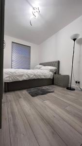 伦敦Lovely and comfortable Home Stay in London的一间卧室配有一张床,铺有木地板