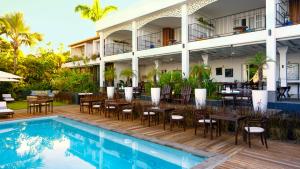 圣勒蓝色马古拉特海景酒店 - 罗莱夏朵精品酒店集团的游泳池旁带桌椅的户外庭院