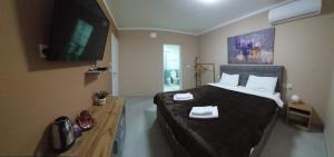 韦莱斯Cholakovi Apartments的一间卧室配有一张大床和一台平面电视