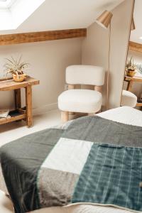 莱代塞尔le chalet de Plainpalais的一间卧室配有一张床、两把椅子和一张桌子