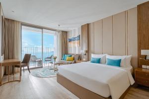 芽庄OceanDream Panorama Luxury Suites的一间酒店客房,设有一张大床和一个大窗户