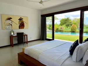坎古Oshan Villas Bali的一间卧室设有一张床,享有游泳池的景色