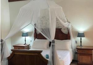 斯瓦科普蒙德Moon Landscape Self Catering的卧室配有带白色床单和枕头的天蓬床。