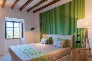 塞尔瓦Agroturisme Subies的一间卧室配有一张带绿色墙壁的床