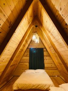里泽Bungi dağ evleri的木制阁楼间内的一张床位,设有窗户