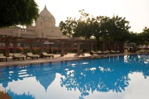 焦特布尔Umaid Bhawan Palace Jodhpur的一个带椅子的游泳池和一个背景建筑