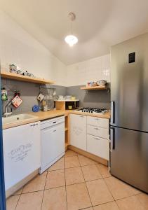 马达莱纳Residenza Aldo Moro 02的厨房配有不锈钢冰箱和白色橱柜