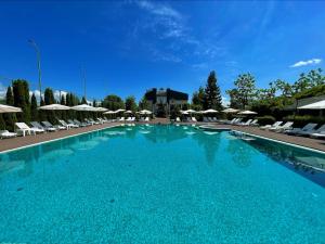 孔泽Platium Spa&Resort的一个带椅子和遮阳伞的大型蓝色游泳池