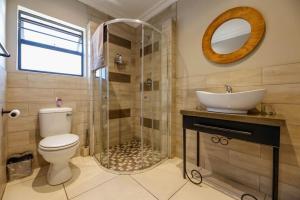 布隆方丹Touching Senses Garden Cottages的浴室配有卫生间、盥洗盆和淋浴。