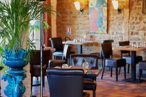 巴泽耶Auberge du port的一间设有桌椅的餐厅和一个蓝色的花瓶