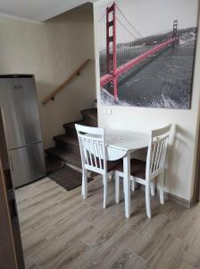 尤尔巴尔卡斯Apartamentai G&G的一张白色的桌子和椅子,上面有金门桥的照片