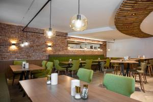 瓦豪地区魏森基兴Weingut Ferdl Denk的餐厅设有木桌和绿色椅子
