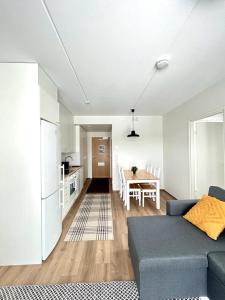 奥卢Kotimaailma Apartments Sairaalanrinne的一间带蓝色沙发的客厅和一间厨房