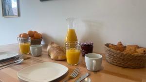 尼奥尔Le Vert’ueux - Appartement tout équipé à Niort的一张桌子,上面放着一瓶橙汁和面包