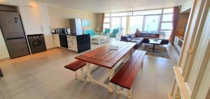 马盖特La Mer 8 - 6 Sleeper - Overlooking Margate Beach!的厨房以及带桌子和沙发的客厅。