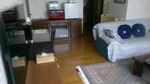 札幌旅の宿ていね的客厅配有床和沙发