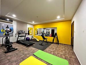 SāhīwālHotel One Sahiwal的健身房设有健身器材和黄色墙壁