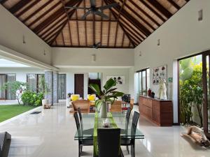 坎古Oshan Villas Bali的开放式客厅配有玻璃桌和椅子