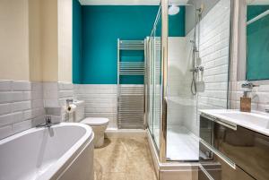 阿什福德2 Bedroom 2 Bathroom in ASHFORD - Next to Station - Perfect for 6 people - Parking & Super Fast Internet的带浴缸、卫生间和淋浴的浴室。