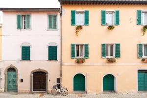 奥尔贝泰洛Noi 2 Vacanze ORBETELLO CENTRO的停在一座绿色百叶窗建筑前面的自行车