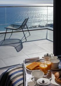 利马索尔ONLY Boutique Suites & Residences的阳台上的桌子上摆放着早餐食品托盘