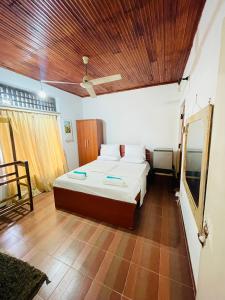 库鲁内格勒曼加拉旅馆的一间卧室设有一张床和木制天花板