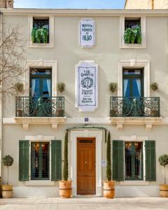 卡瓦永Le 215 Gambetta boutique hôtel en Provence的一座带绿色百叶窗和木门的建筑