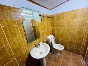 库鲁内格勒曼加拉旅馆的一间带卫生间、水槽和镜子的浴室