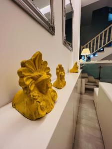 米克诺斯城玛朵齐雅妮酒店的两个黄色雕塑坐在一个房间里一个白色的柜台上