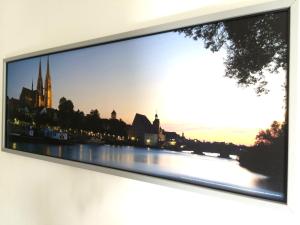 雷根斯堡Apartment Sunshine的挂在墙上的电视,上面有一张河流的照片